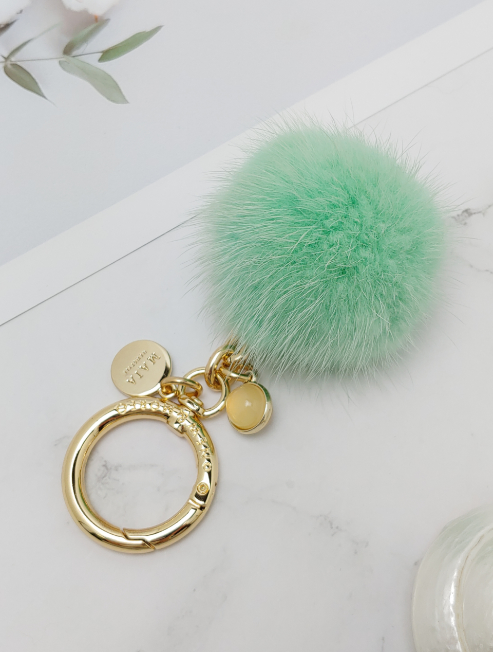 Full shot of the keyring. The clasp and pendant are placed downward, showing the metal details clearly.