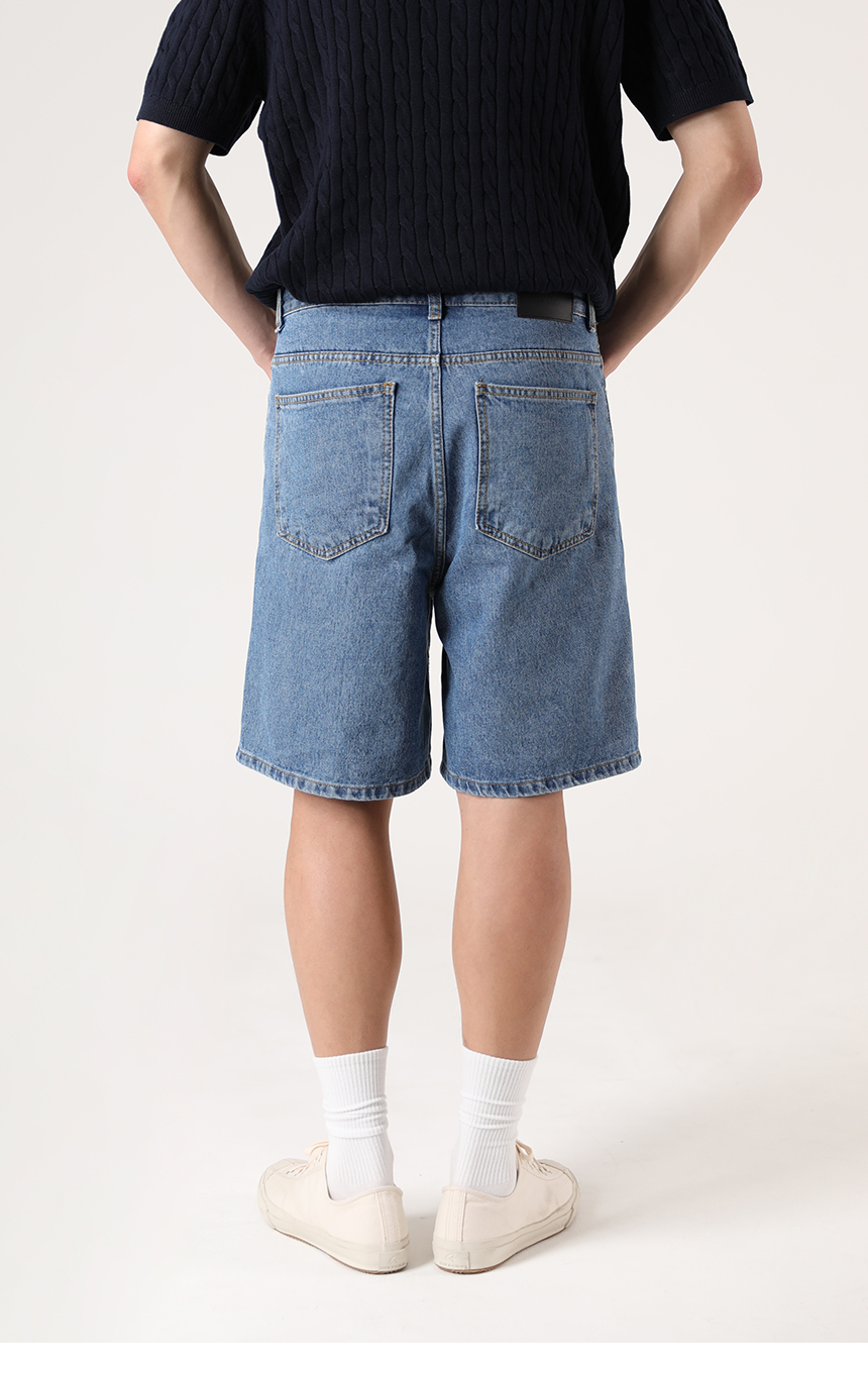 반팔니트와 함께 착용한 중청컬러의 버뮤다팬츠 기장의 미디엄블루 하프데님을 착용한 모델사진