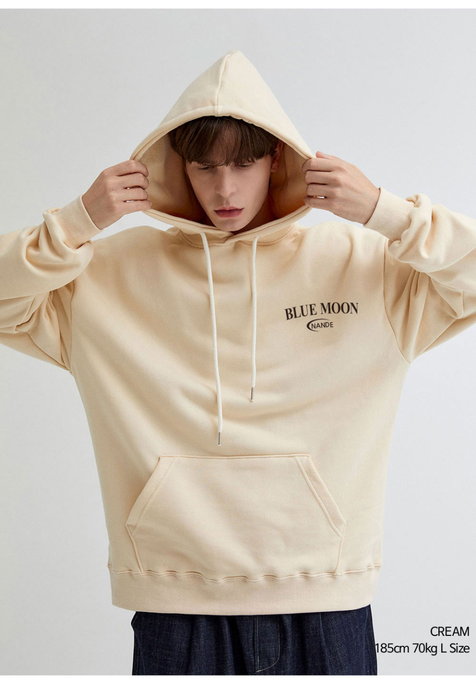 크림색상 달 프린팅 후드티를 입은 남자