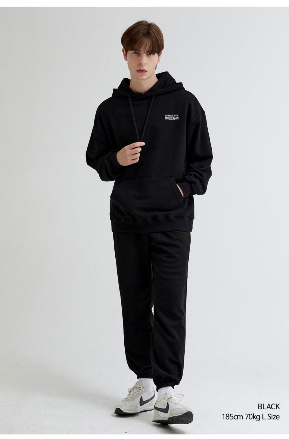 히말라야 산모양 전사를 찍은 네이비색상 후드티를 입은 남자 사진