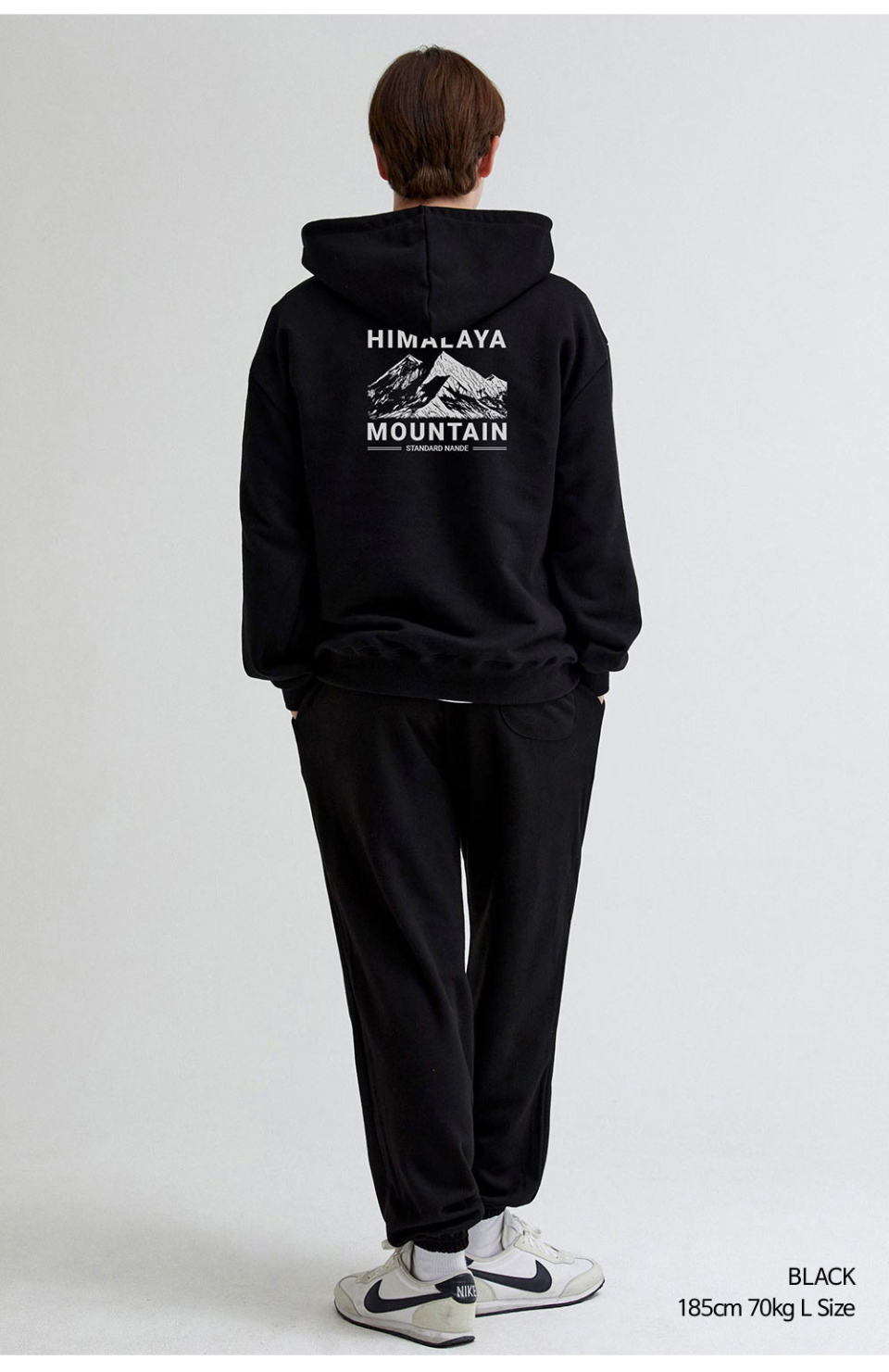 히말라야 산모양 전사를 찍은 네이비색상 후드티를 입은 남자 사진