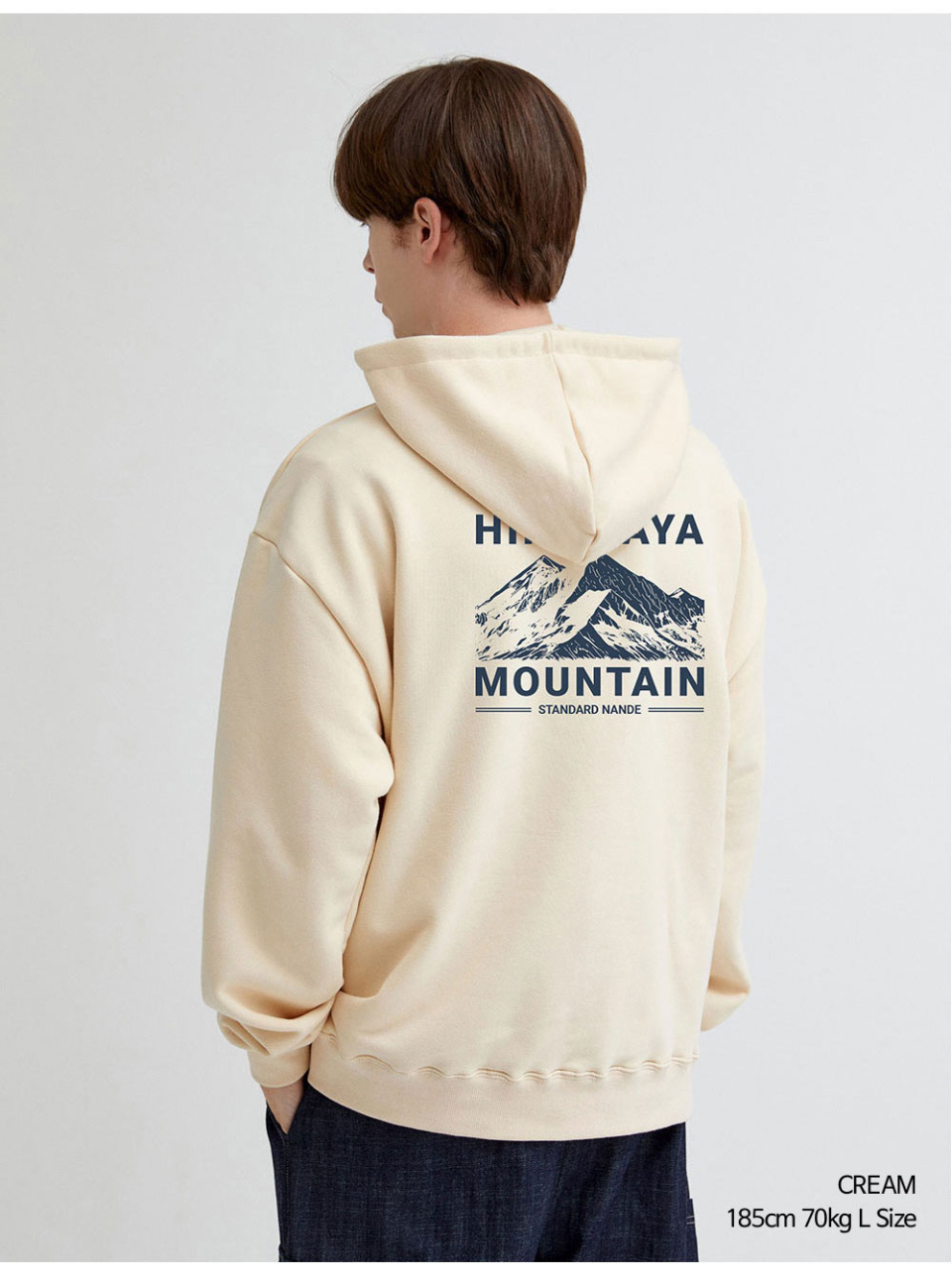 히말라야 산모양 전사를 찍은 크림색상 후드티를 입은 남자 사진