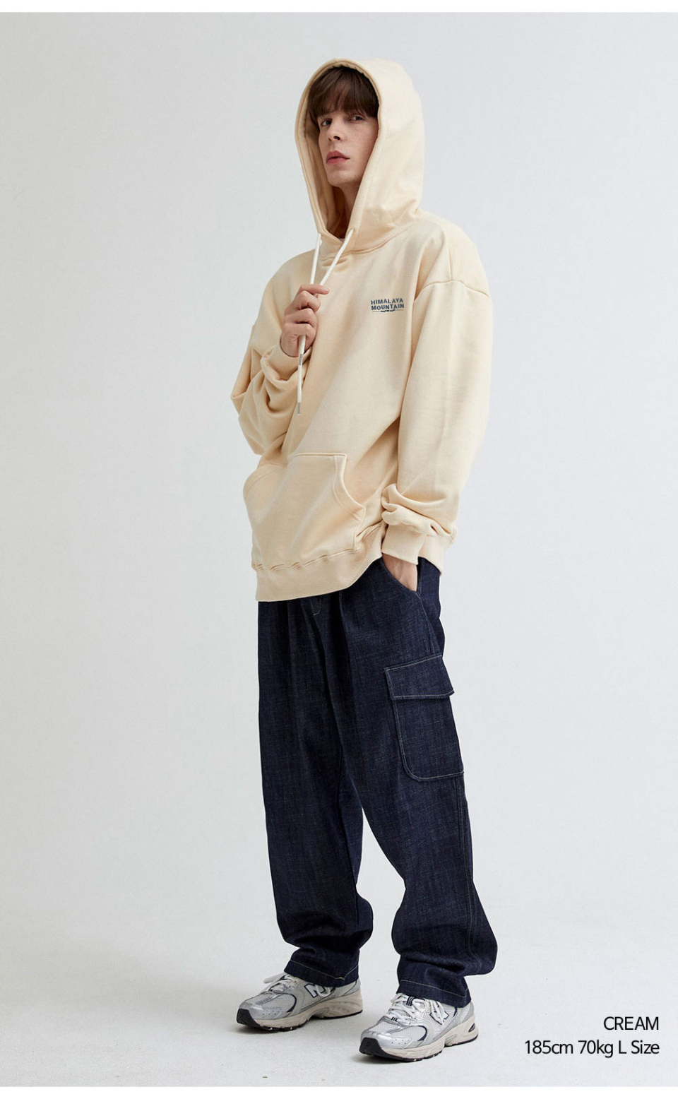 히말라야 산모양 전사를 찍은 크림색상 후드티를 입은 남자 사진