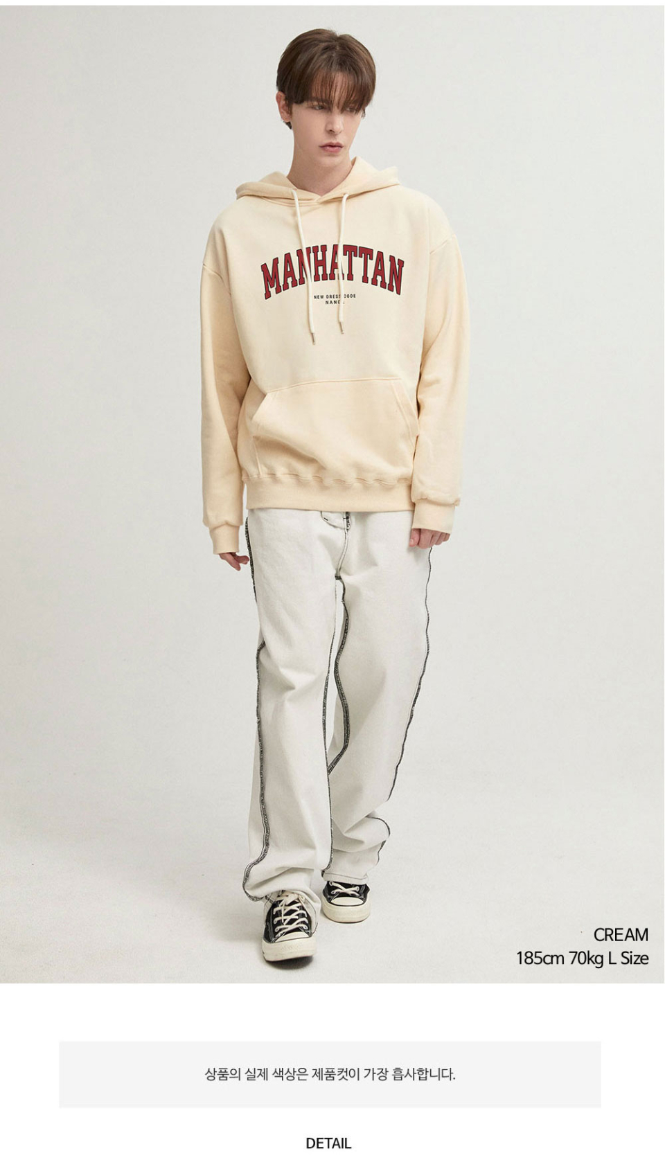 크림색상 멘헤튼 글자가 옷 가슴부분에 찍혀있는 맨투맨을 입은 남자 사진 