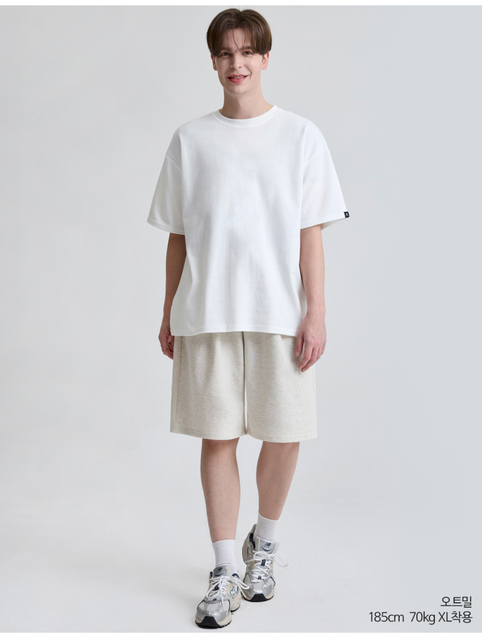 오트밀색상 하나의 턱이있는 와이드핏 반바지를 입은 남자