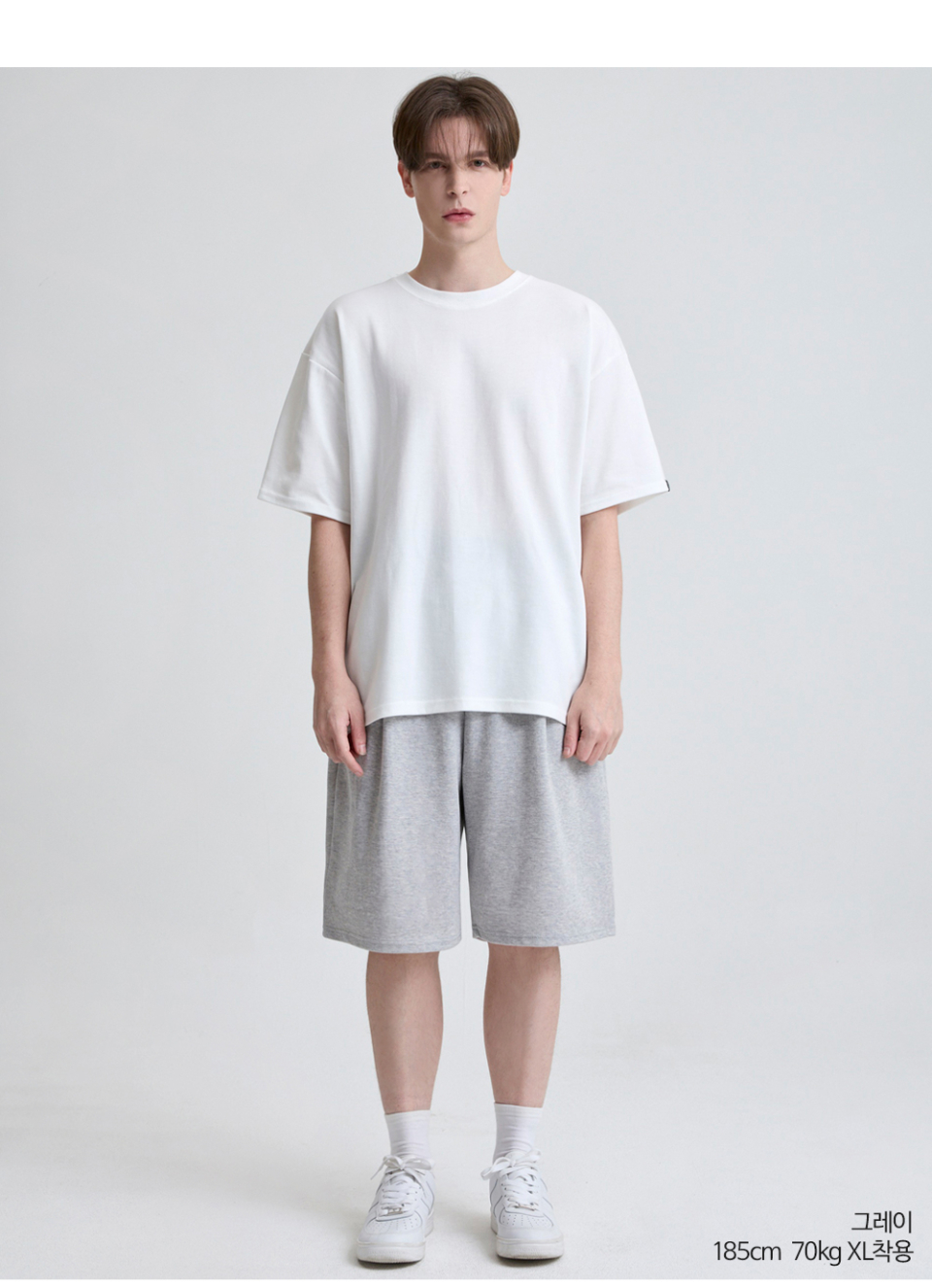 그레이색상 하나의 턱이있는 와이드핏 반바지를 입은 남자