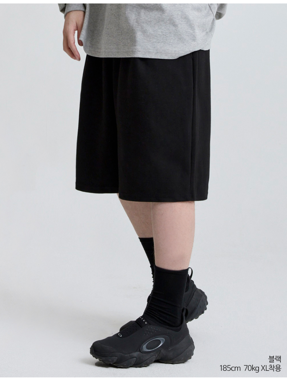 블랙색상 하나의 턱이있는 와이드핏 반바지를 입은 남자