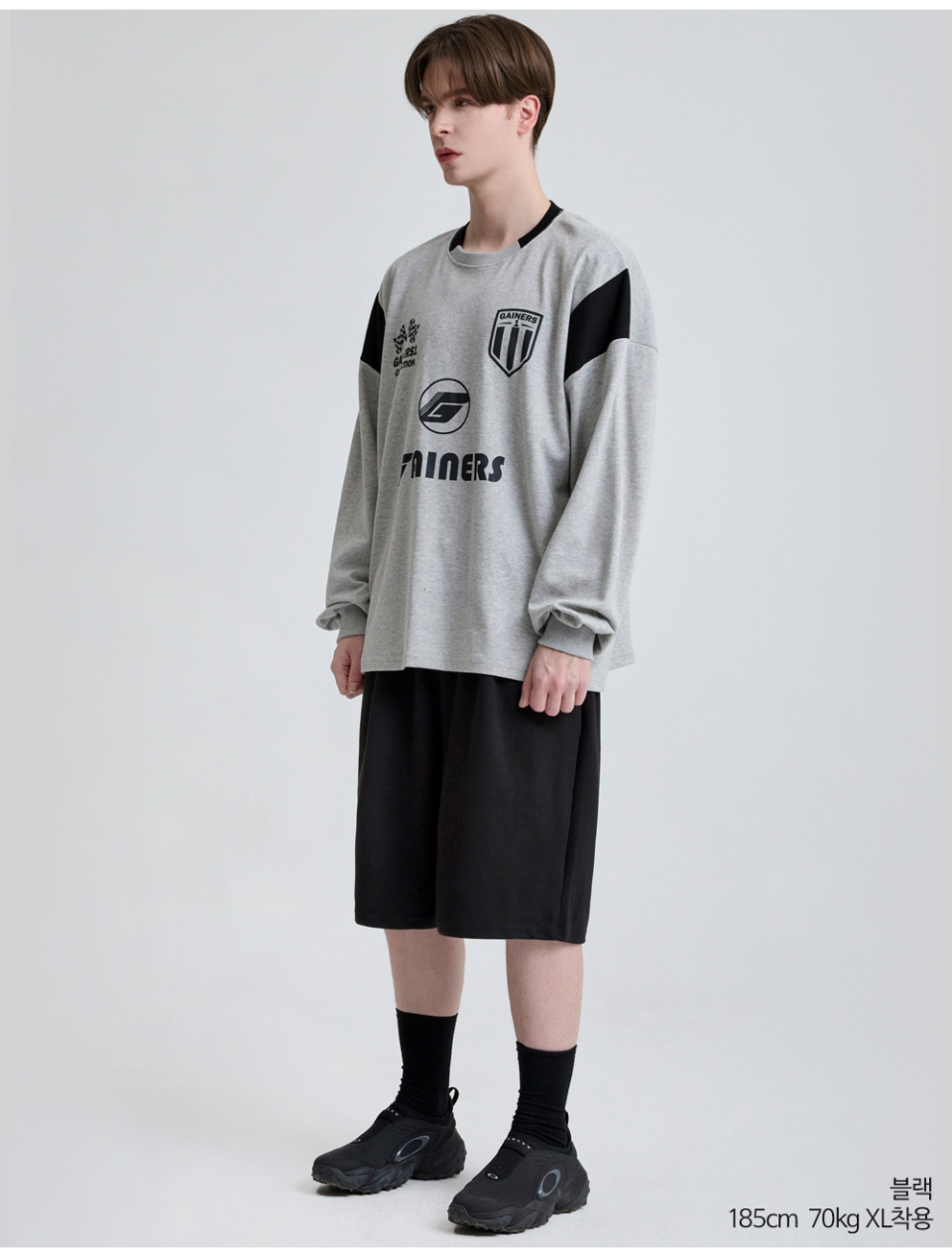 블랙색상 하나의 턱이있는 와이드핏 반바지를 입은 남자