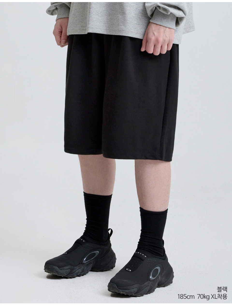 블랙색상 하나의 턱이있는 와이드핏 반바지를 입은 남자