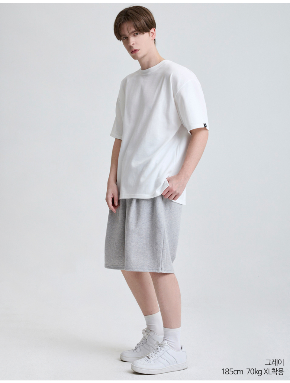 그레이색상 하나의 턱이있는 와이드핏 반바지를 입은 남자