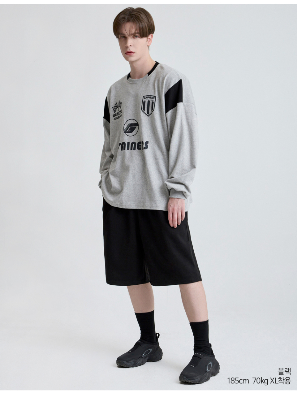 블랙색상 하나의 턱이있는 와이드핏 반바지를 입은 남자