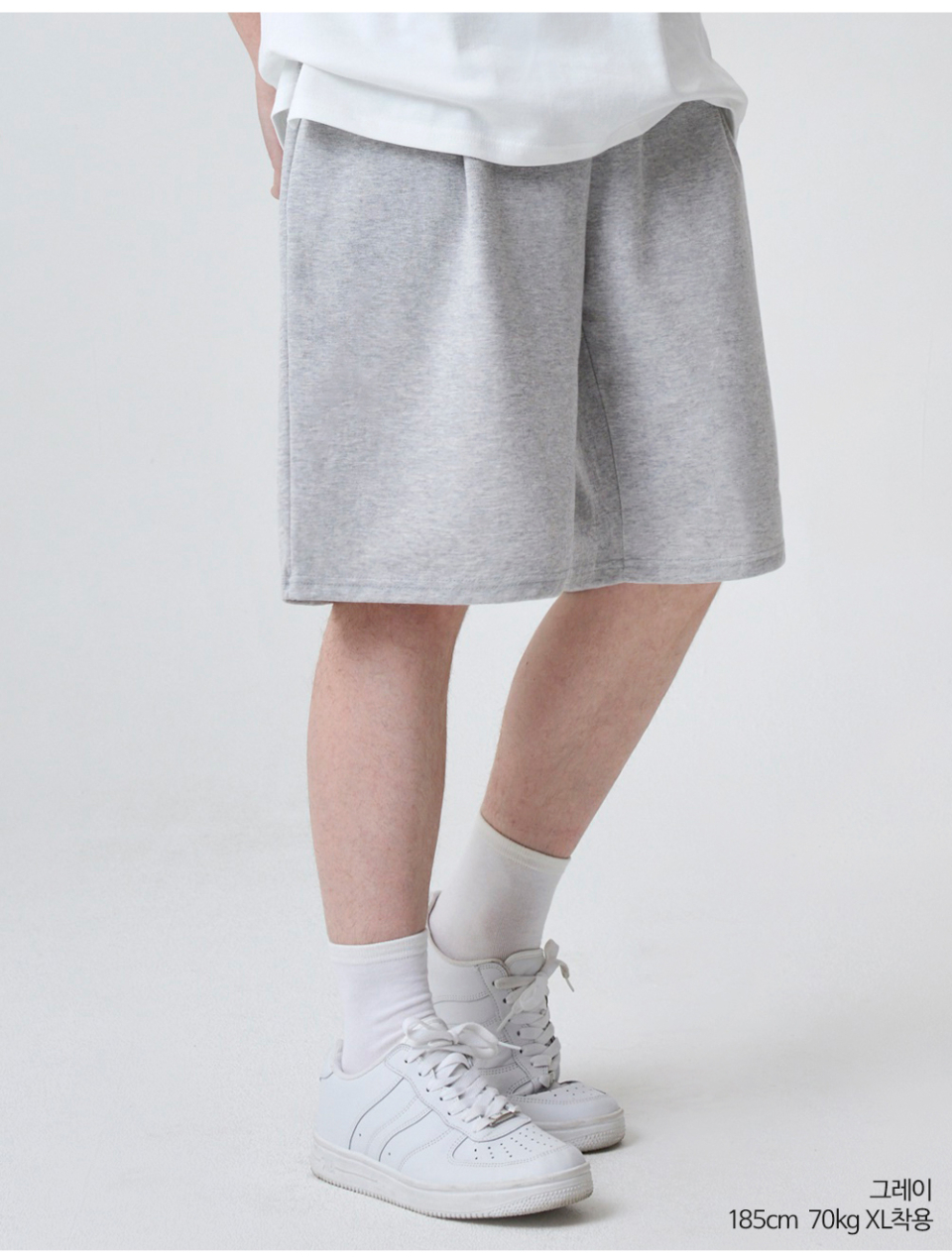 그레이색상 하나의 턱이있는 와이드핏 반바지를 입은 남자
