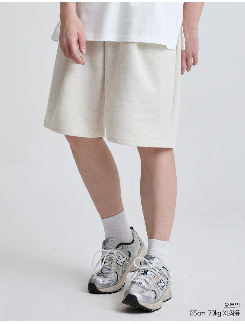 오트밀색상 하나의 턱이있는 와이드핏 반바지를 입은 남자