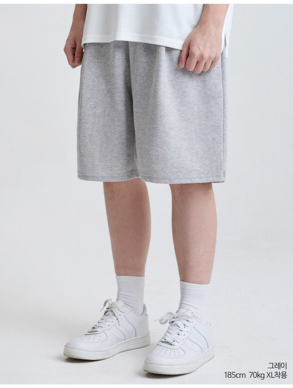그레이색상 하나의 턱이있는 와이드핏 반바지를 입은 남자