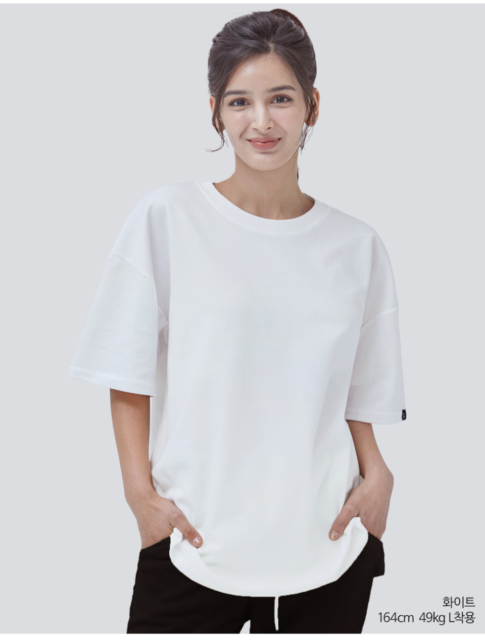 흰색 팔에 포인트로 라벨이 붙어있는 옷을 입은 여자사진