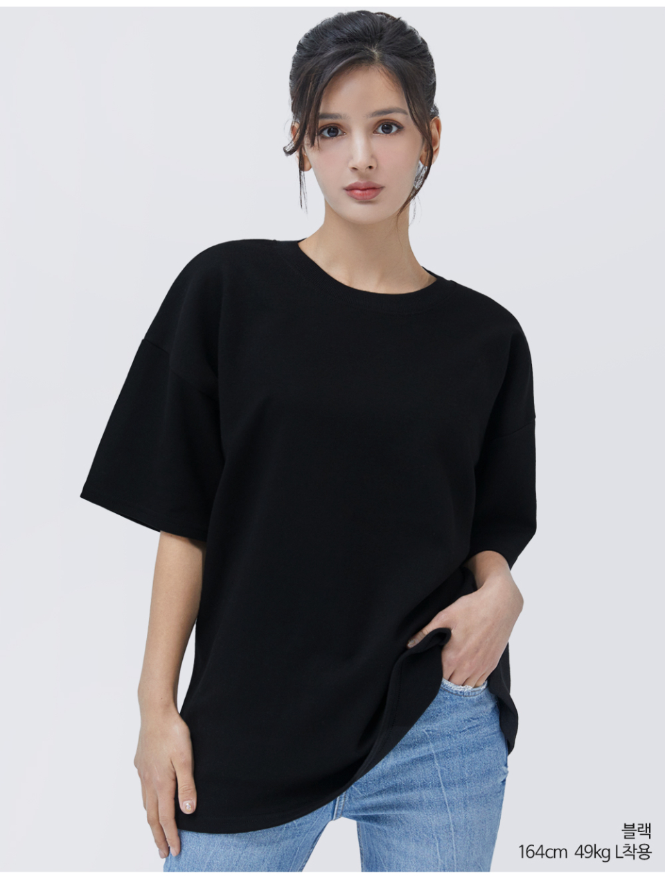 검정색옷 팔에 포인트로 라벨이 붙어있는 옷을 입은 여자사진