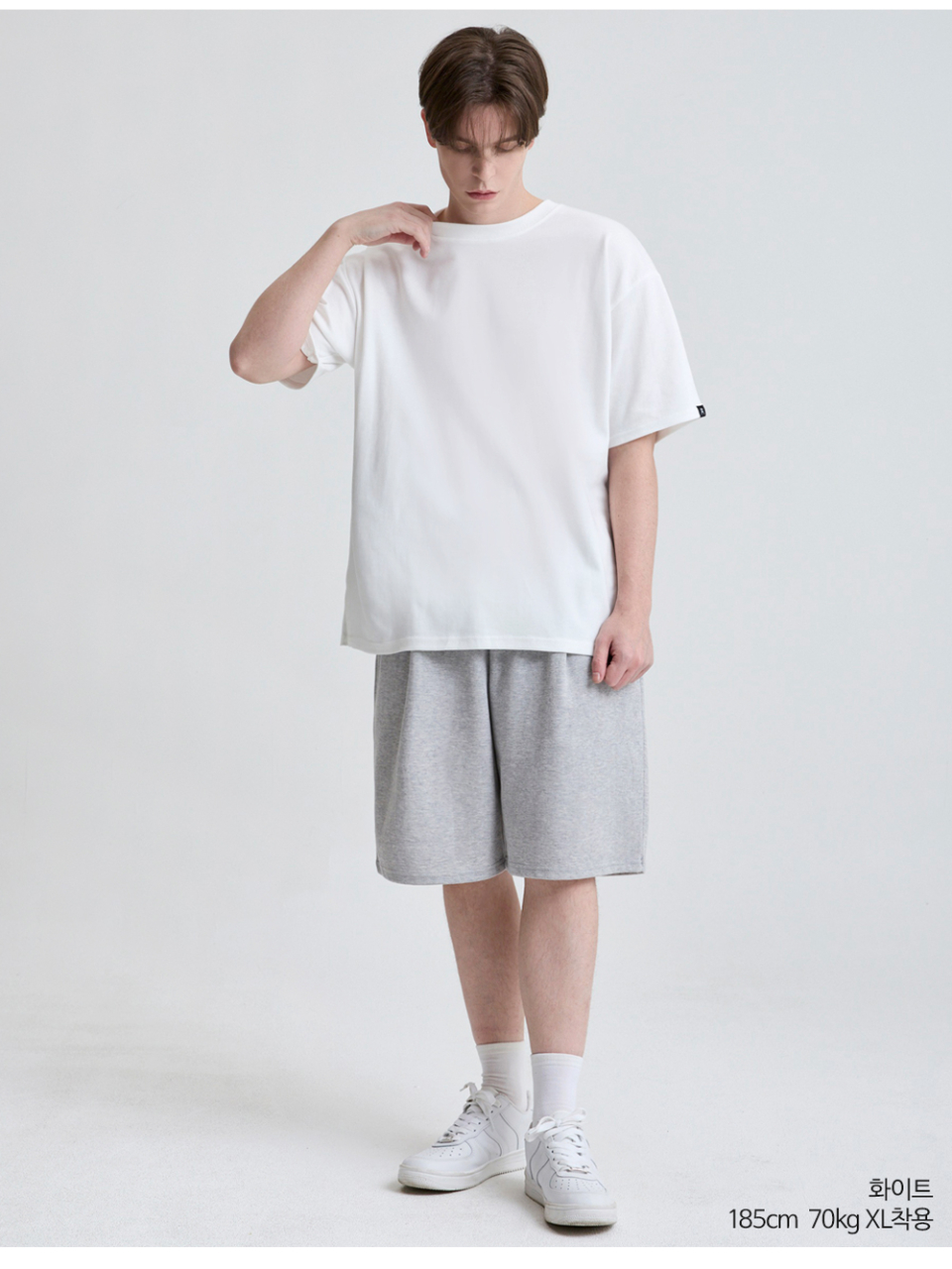 흰색 팔에 포인트로 라벨이 붙어있는 옷을 입은 남자사진