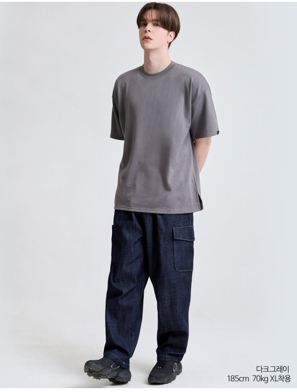 다크그레이색옷 팔에 포인트로 라벨이 붙어있는 옷을 입은 남자사진