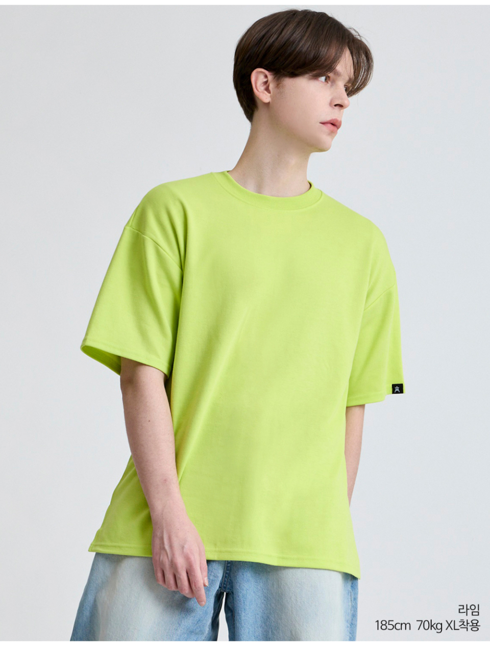 라임색옷 팔에 포인트로 라벨이 붙어있는 옷을 입은 남자사진