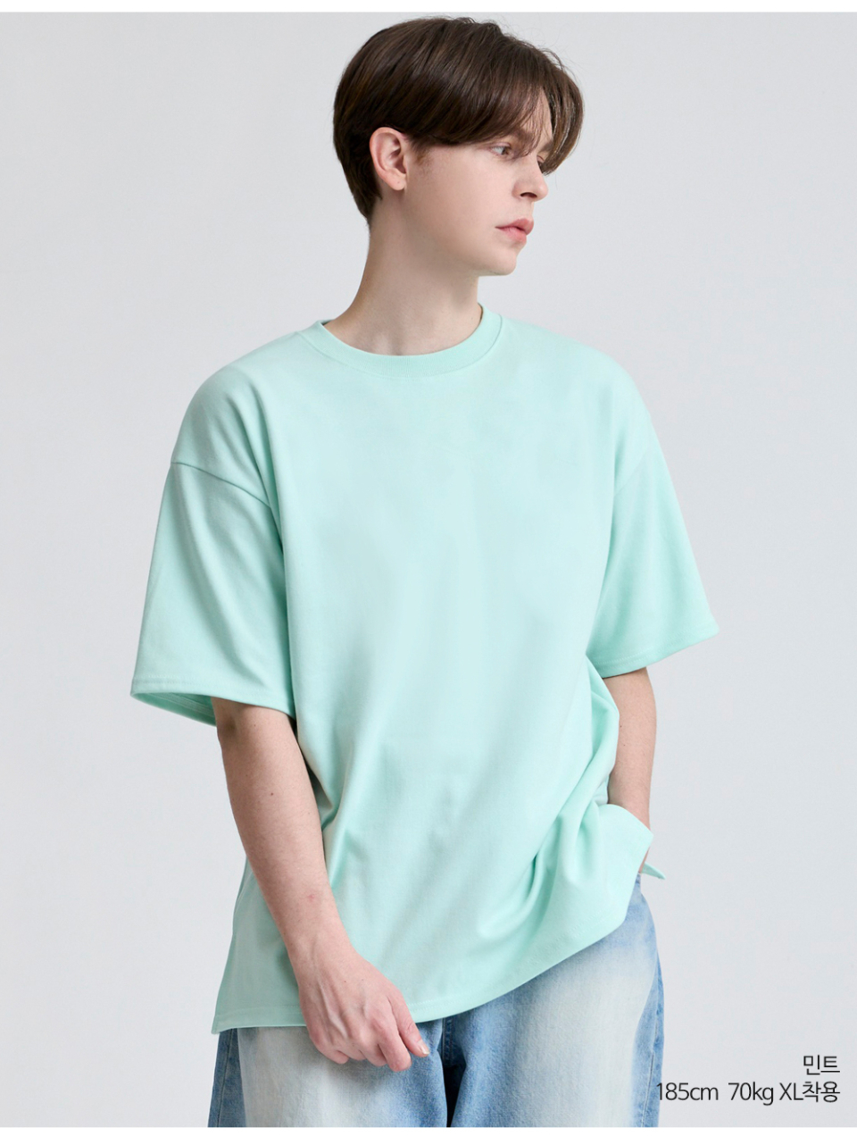 민트색옷 팔에 포인트로 라벨이 붙어있는 옷을 입은 남자사진