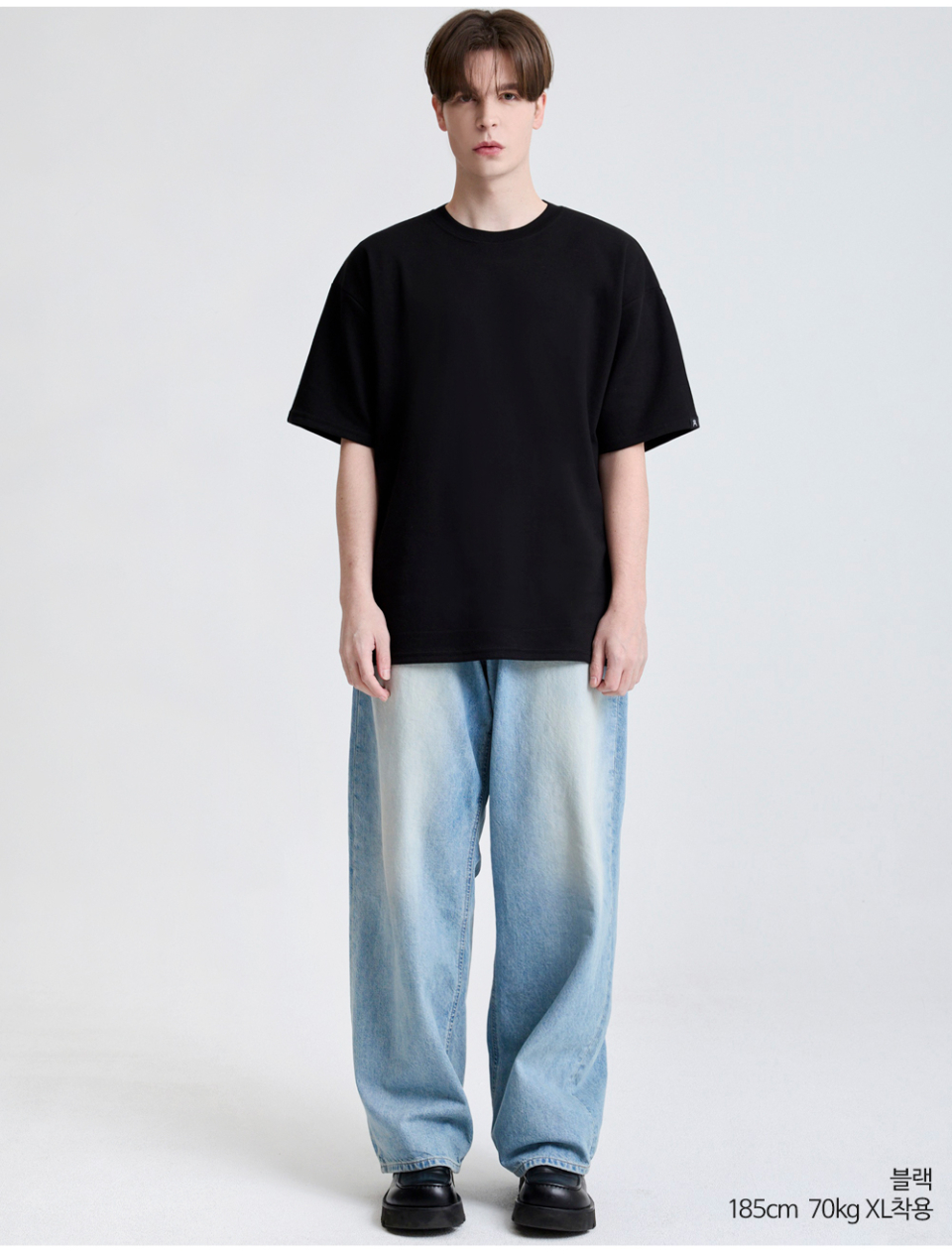 검정색 팔에 포인트로 라벨이 붙어있는 옷을 입은 남자사진