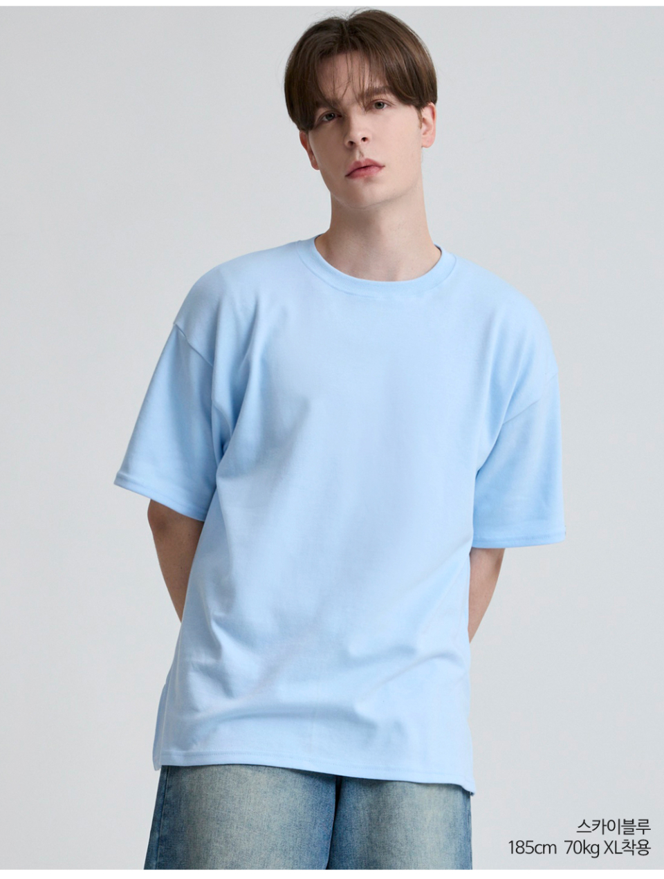 스카이블루색옷 팔에 포인트로 라벨이 붙어있는 옷을 입은 남자사진