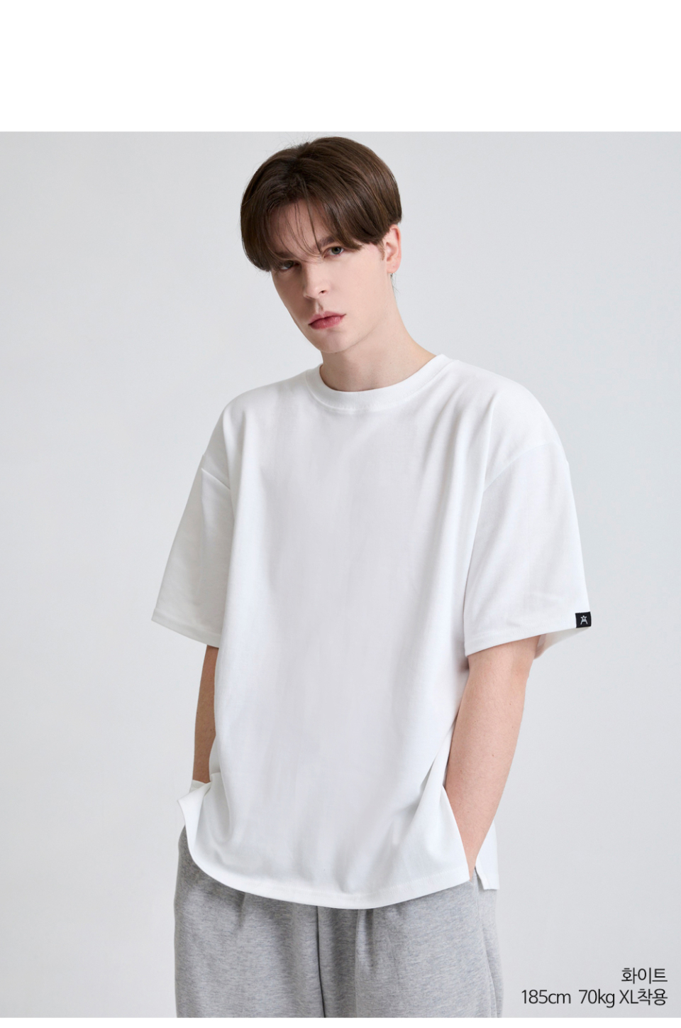 흰색 팔에 포인트로 라벨이 붙어있는 옷을 입은 남자사진