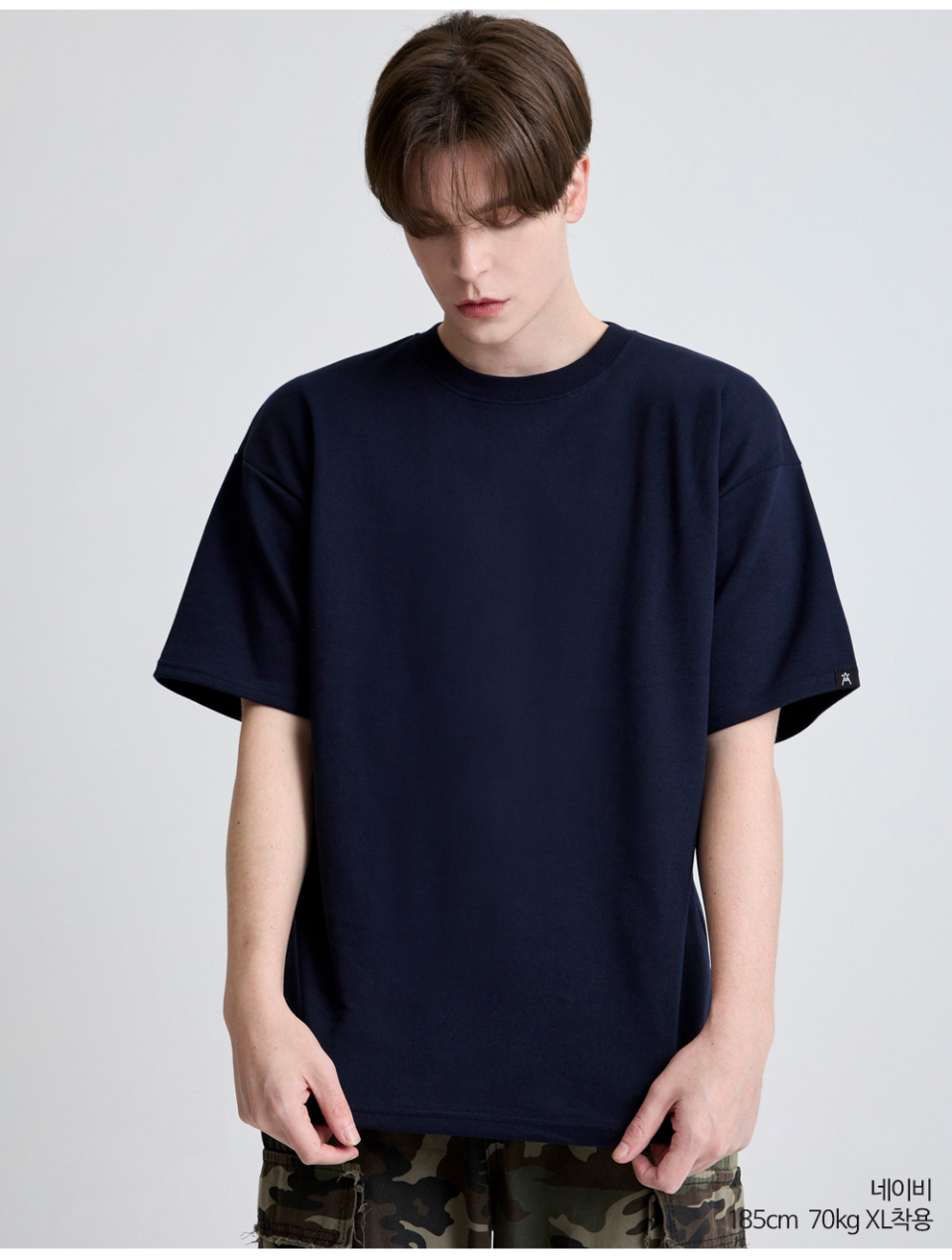 네이비색옷 팔에 포인트로 라벨이 붙어있는 옷을 입은 남자사진