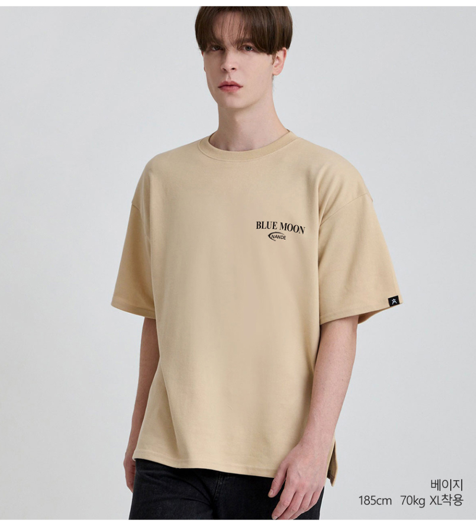 베이지색상 뒷면에 달 프린팅이 있는 반팔 티셔츠를 입은 남자사진