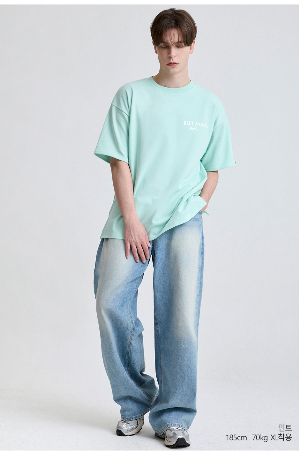 민트색상 뒷면에 달 프린팅이 있는 반팔 티셔츠를 입은 남자사진