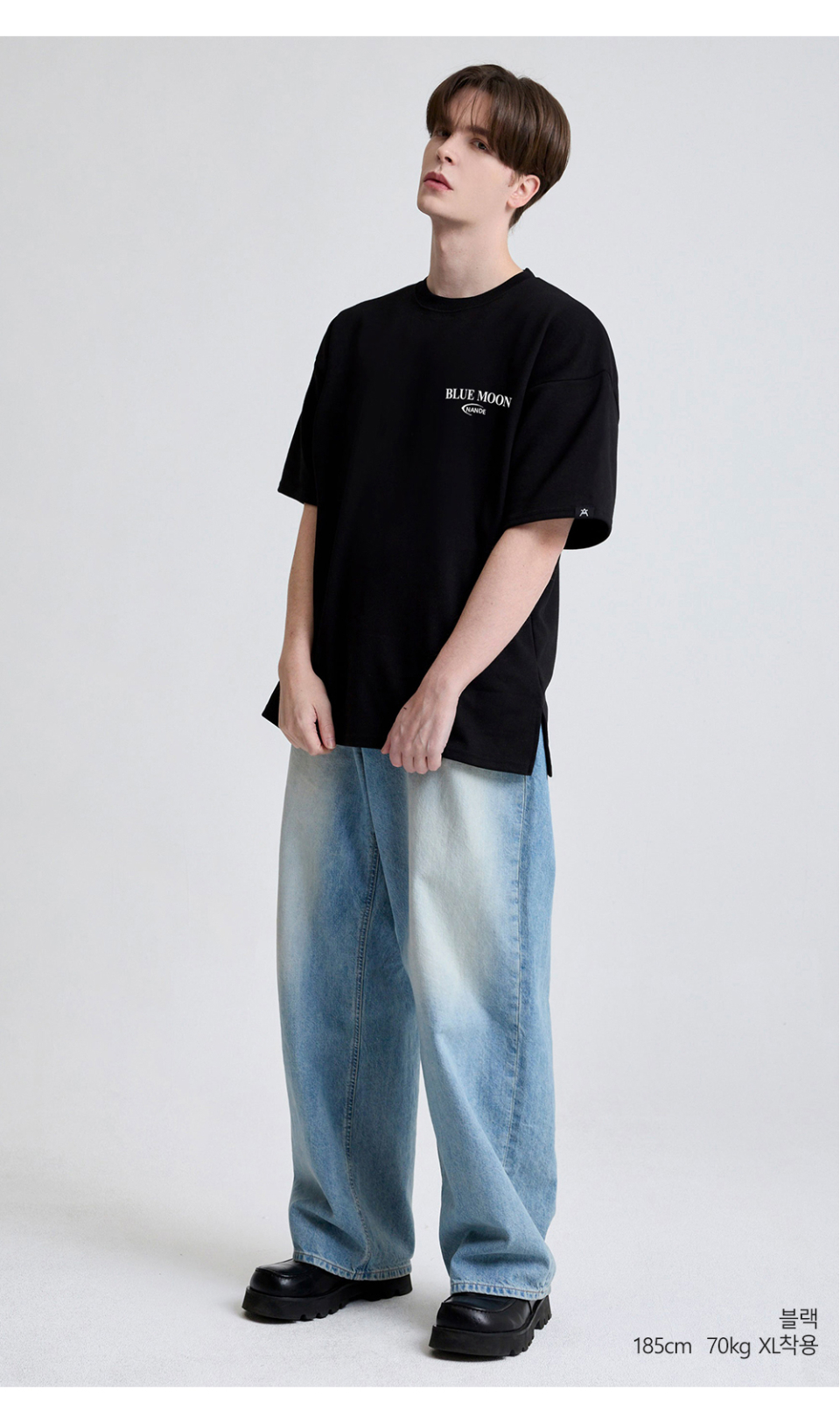 블랙색상 뒷면에 달 프린팅이 있는 반팔 티셔츠를 입은 남자사진