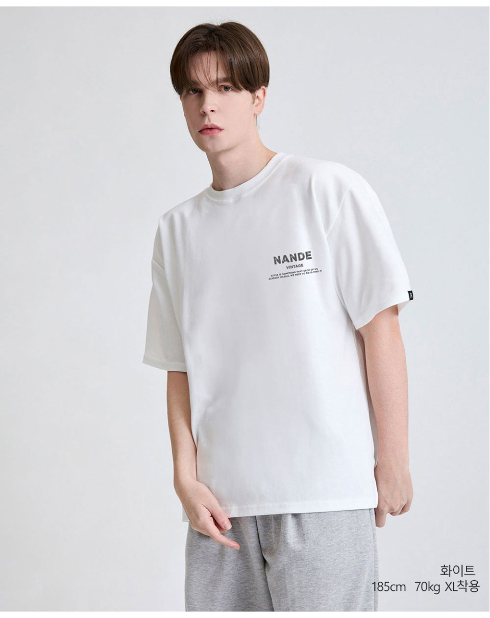 화이트색상 빈티지로고가 왼쪽가슴에 찍힌 티셔츠를 입은 남자사진
