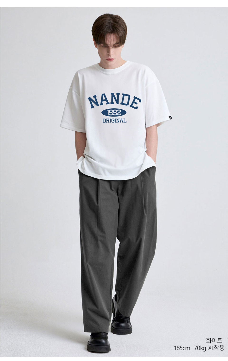 화이트색상 가슴에 NANDE 글씨가 적혀있는  티셔츠를 입고있는 남자사진