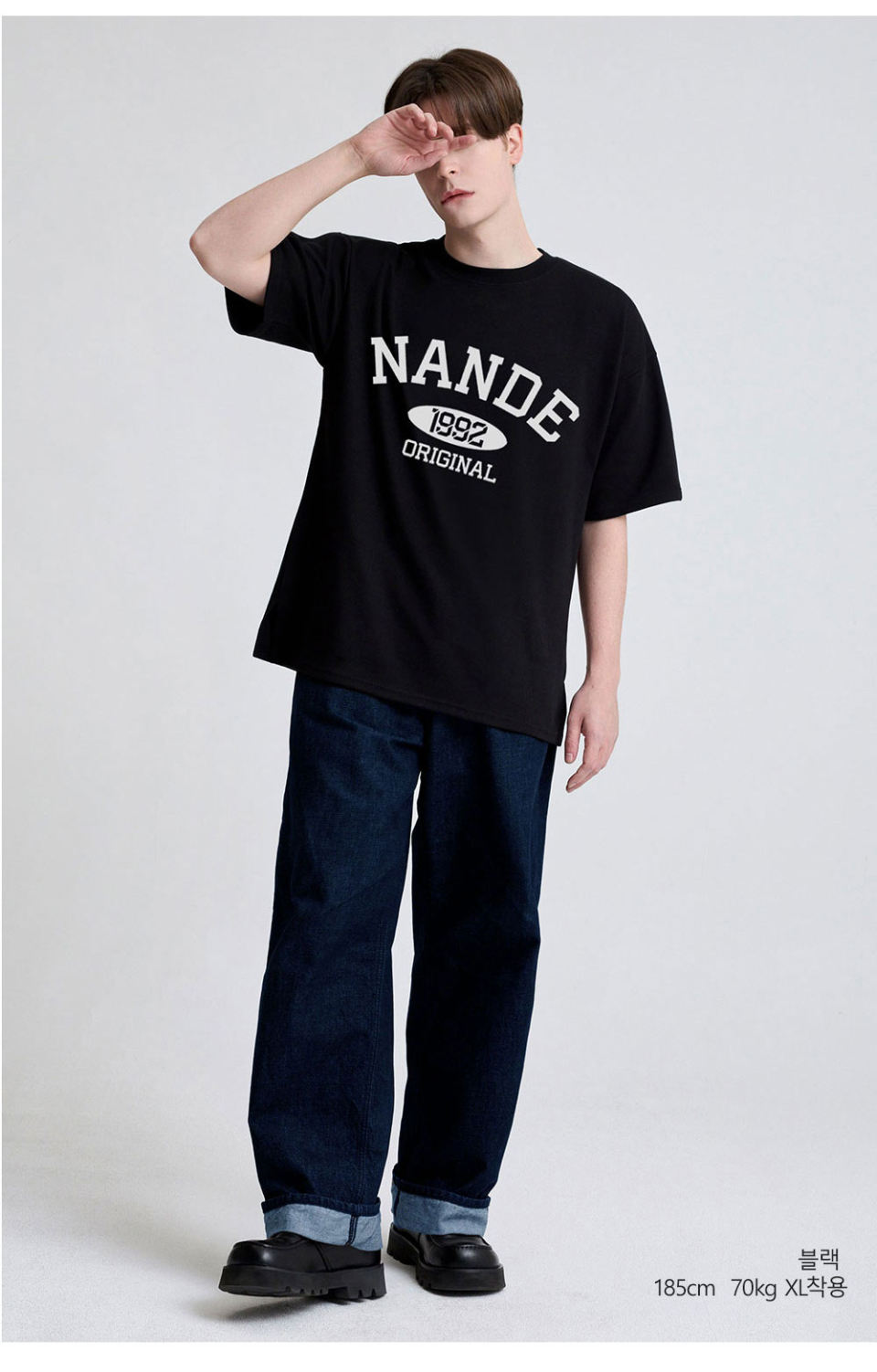 블랙색상 가슴에 NANDE 글씨가 적혀있는  티셔츠를 입고있는 남자사진