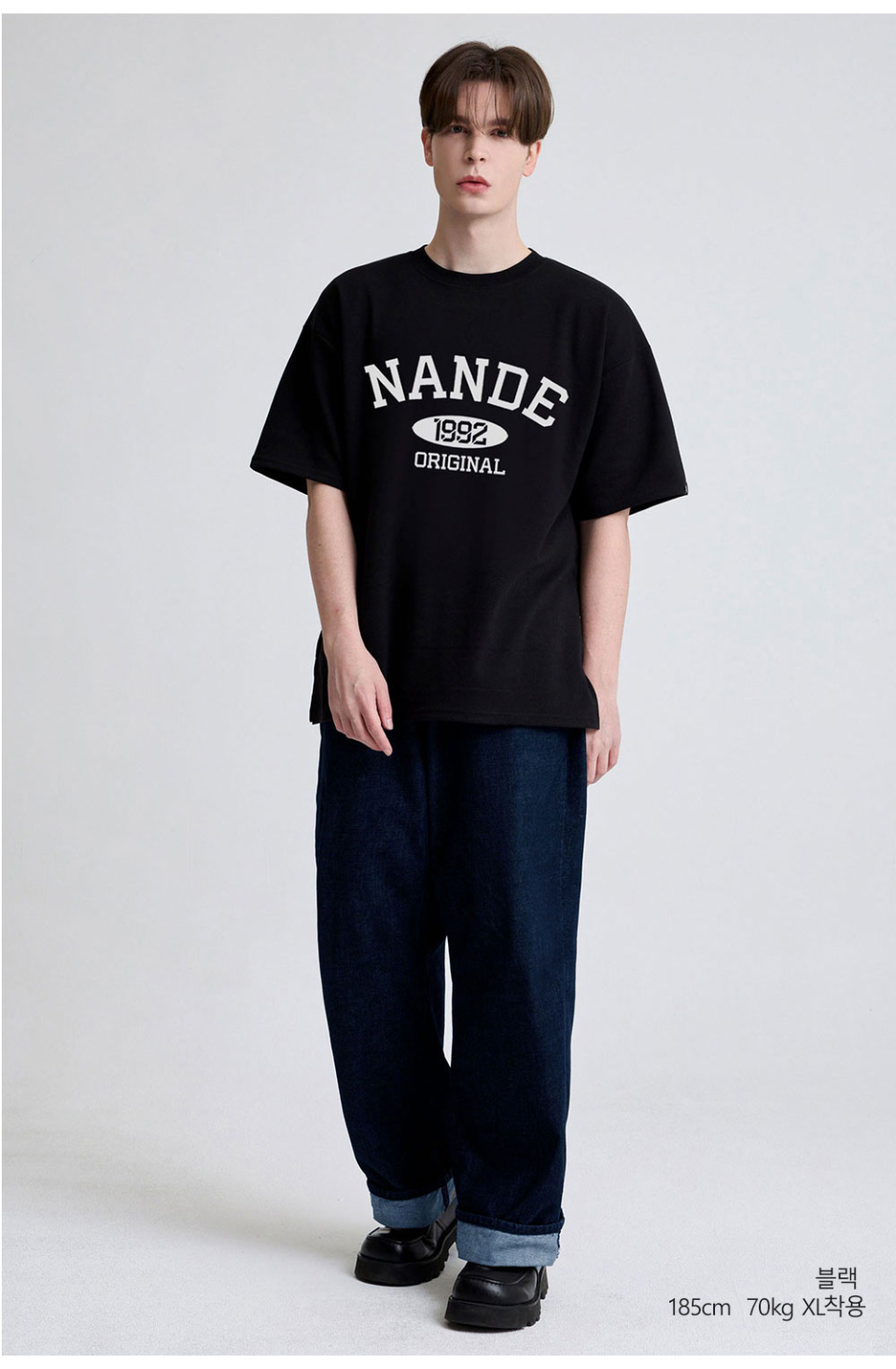 블랙색상 가슴에 NANDE 글씨가 적혀있는  티셔츠를 입고있는 남자사진