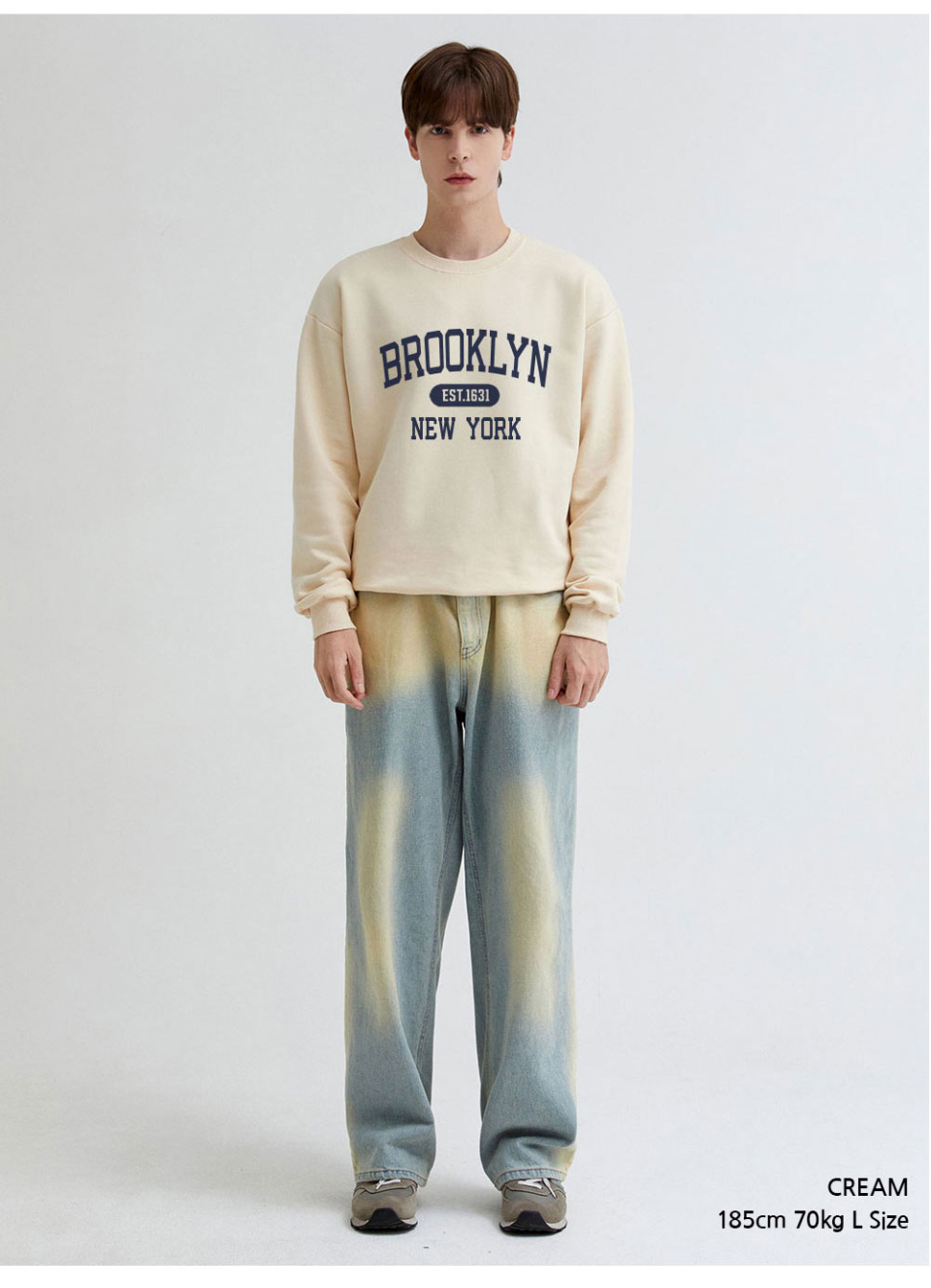 크림색상 brooklyn 전사가 찍힌 맨투맨을 입은 남자사진 