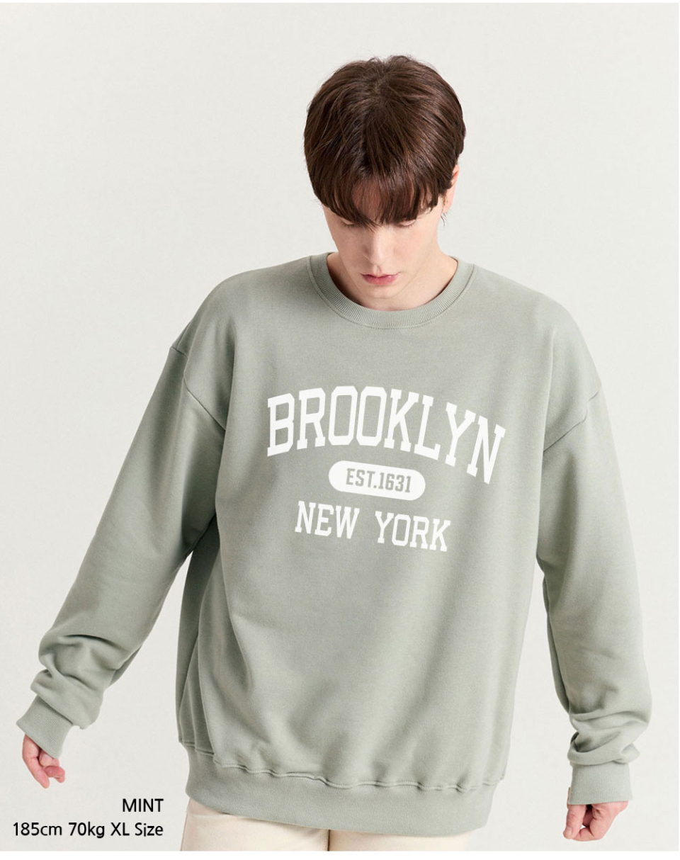 민트색상 brooklyn 전사가 찍힌 맨투맨을 입은 남자사진 