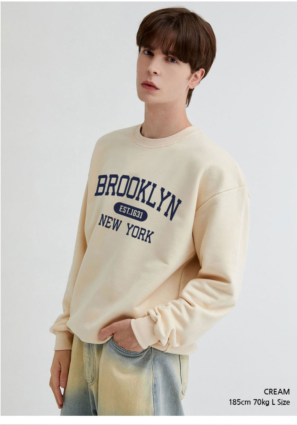 크림색상 brooklyn 전사가 찍힌 맨투맨을 입은 남자사진 