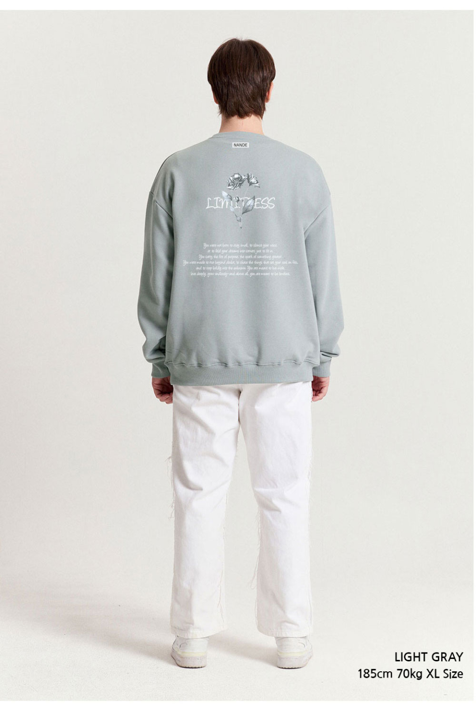 라이트그레이색상 장미그림이 등판에 찍혀있는 맨투맨을 입은 남자 사진