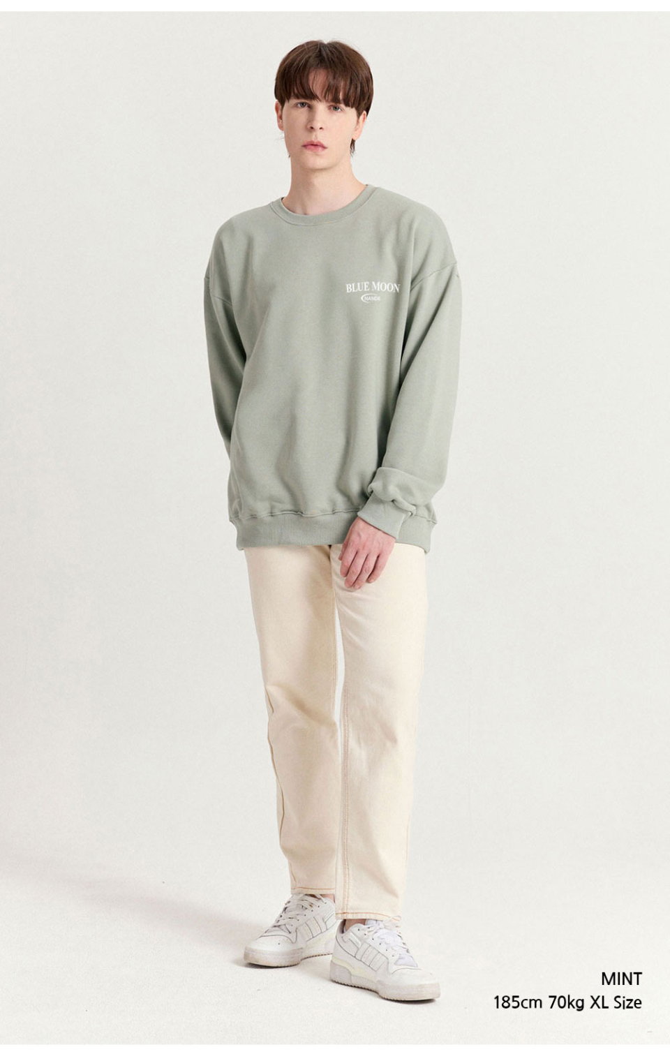 민트색상 달이 등에 프린팅된 맨투맨을 입은 남자 사진