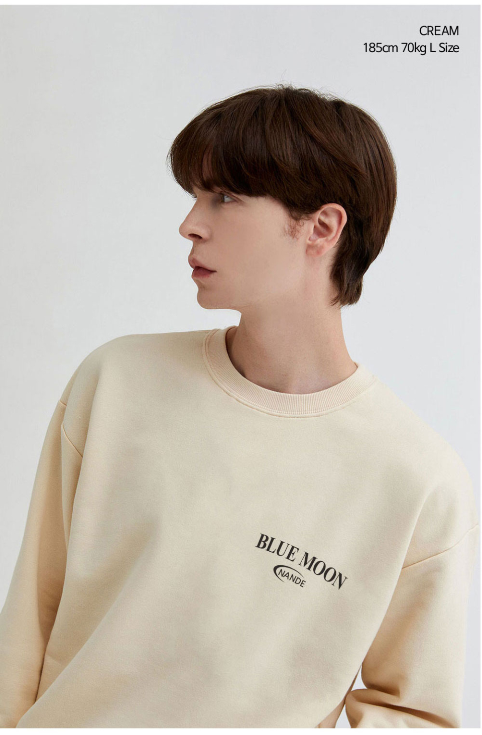 크림색상 달이 등에 프린팅된 맨투맨을 입은 남자 사진