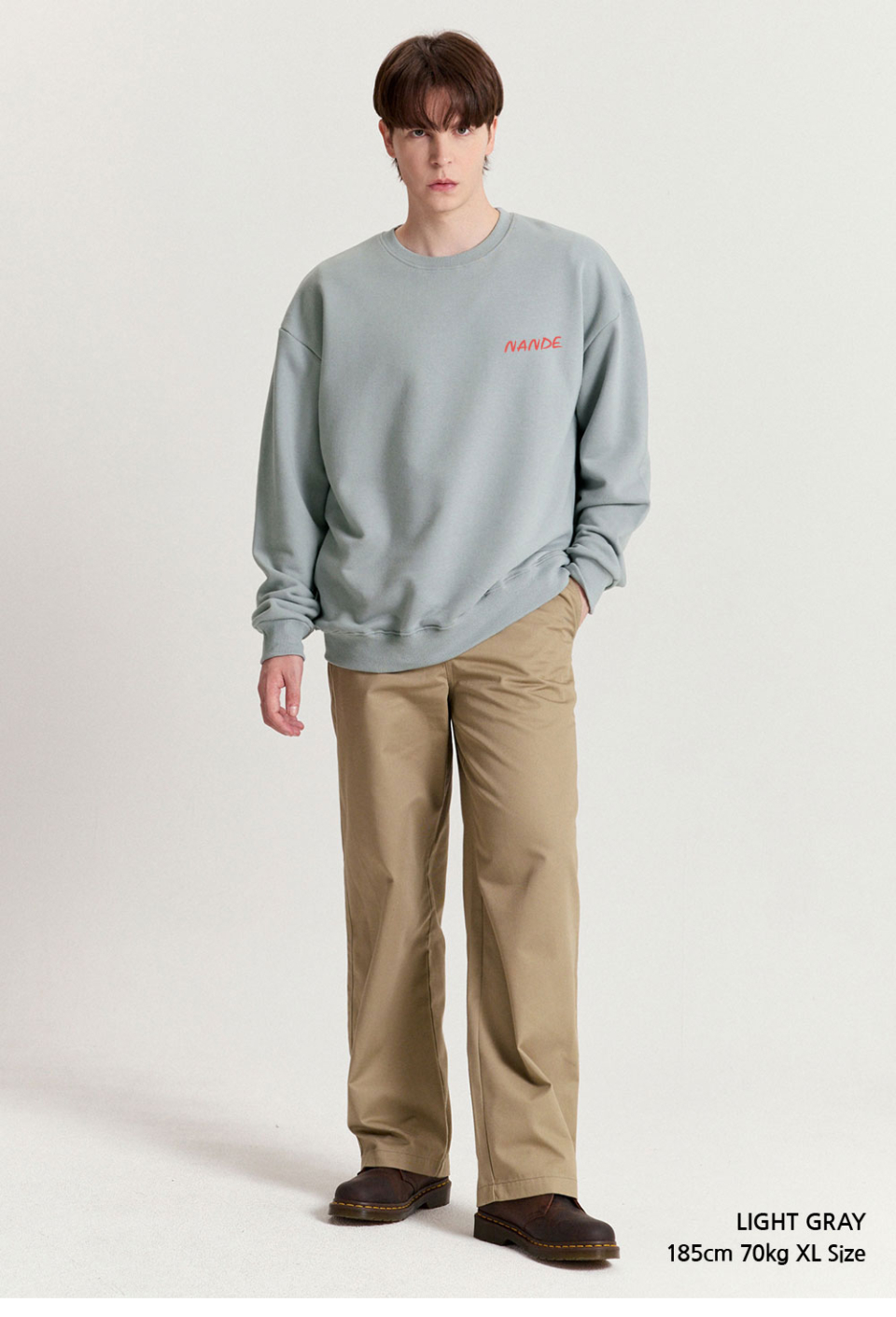 라이트그레이 색상 등에 꽃이 프린팅 되어있는 맨투맨을입은 남자 사진