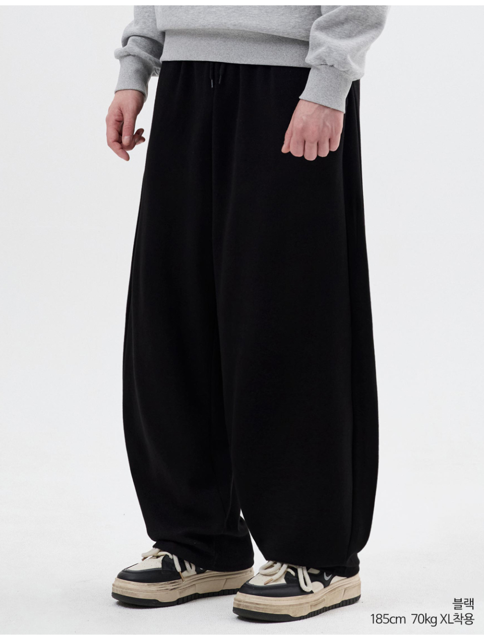 블랙색상 사이드턱이있는 벌룬 팬츠를 입은 남자사진