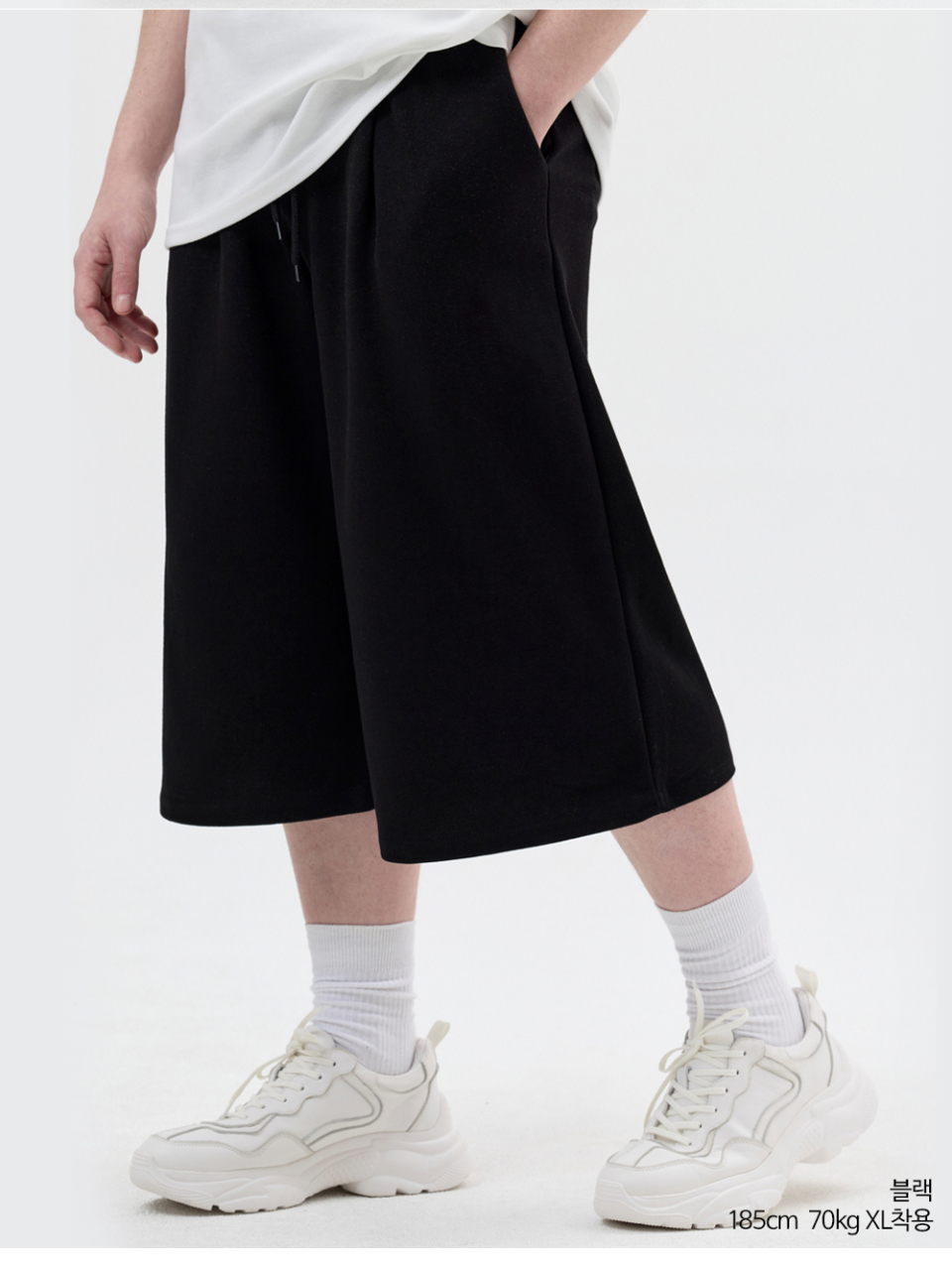 블랙색상 8부 원턱 버뮤다 쇼츠를 입은 남자 사진