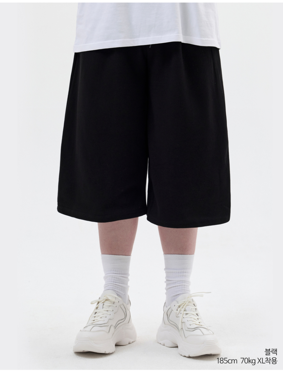 블랙색상 8부 원턱 버뮤다 쇼츠를 입은 남자 사진
