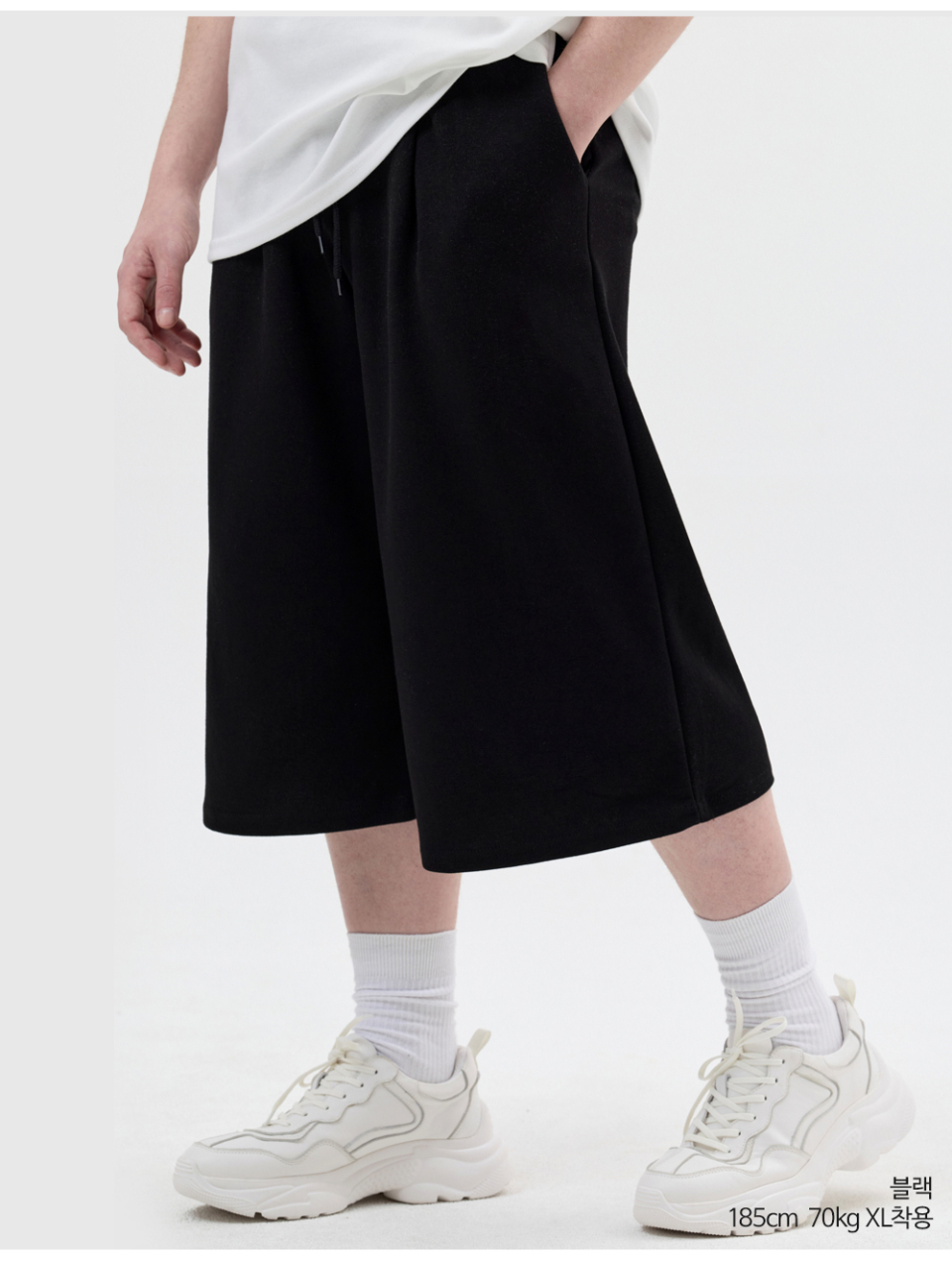 블랙색상 8부 원턱 버뮤다 쇼츠를 입은 남자 사진