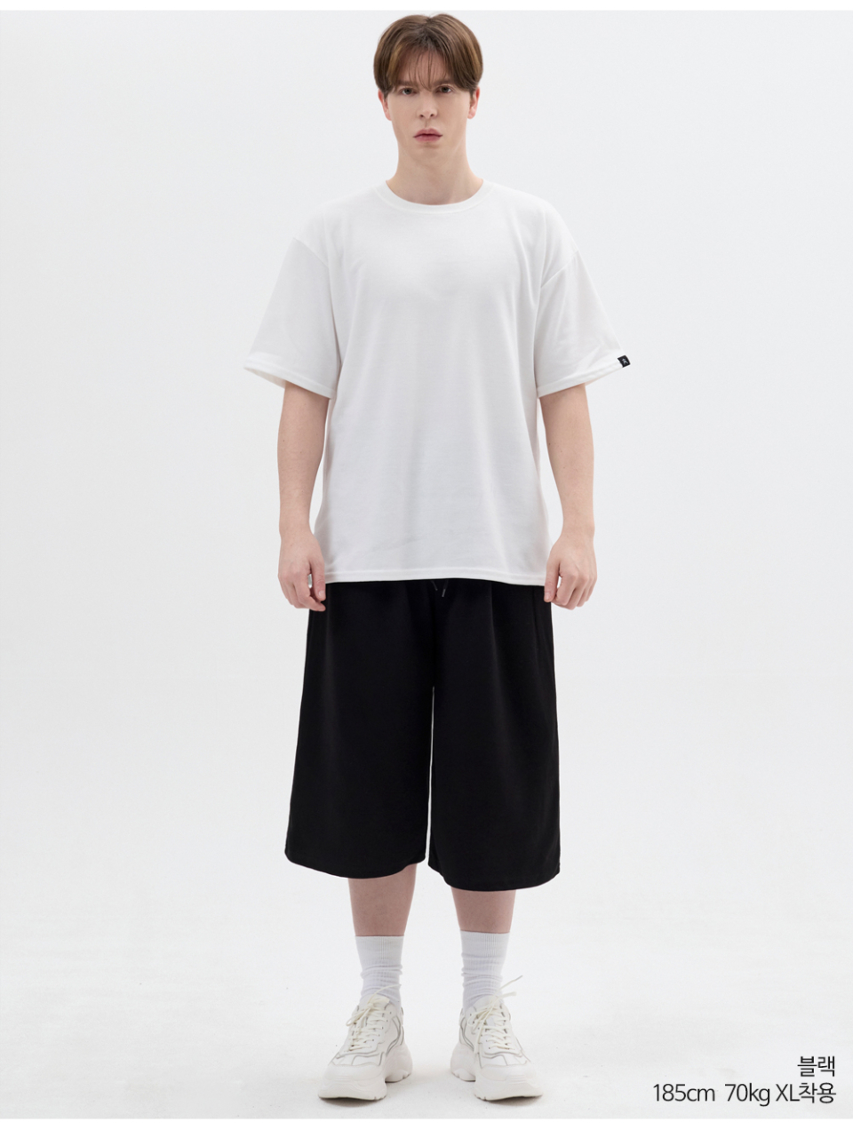 블랙색상 8부 원턱 버뮤다 쇼츠를 입은 남자 사진