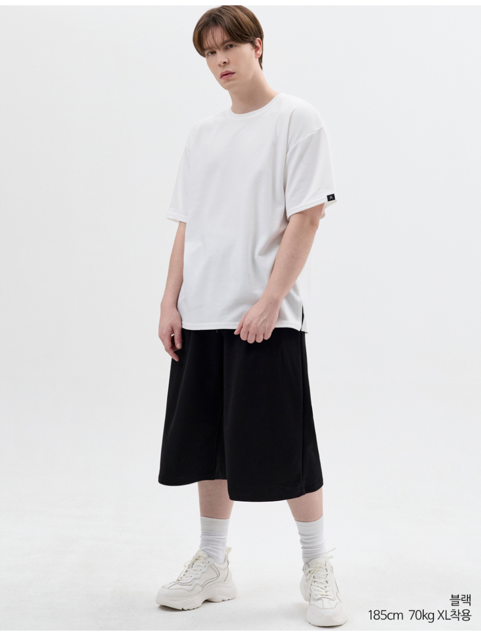 블랙색상 8부 원턱 버뮤다 쇼츠를 입은 남자 사진