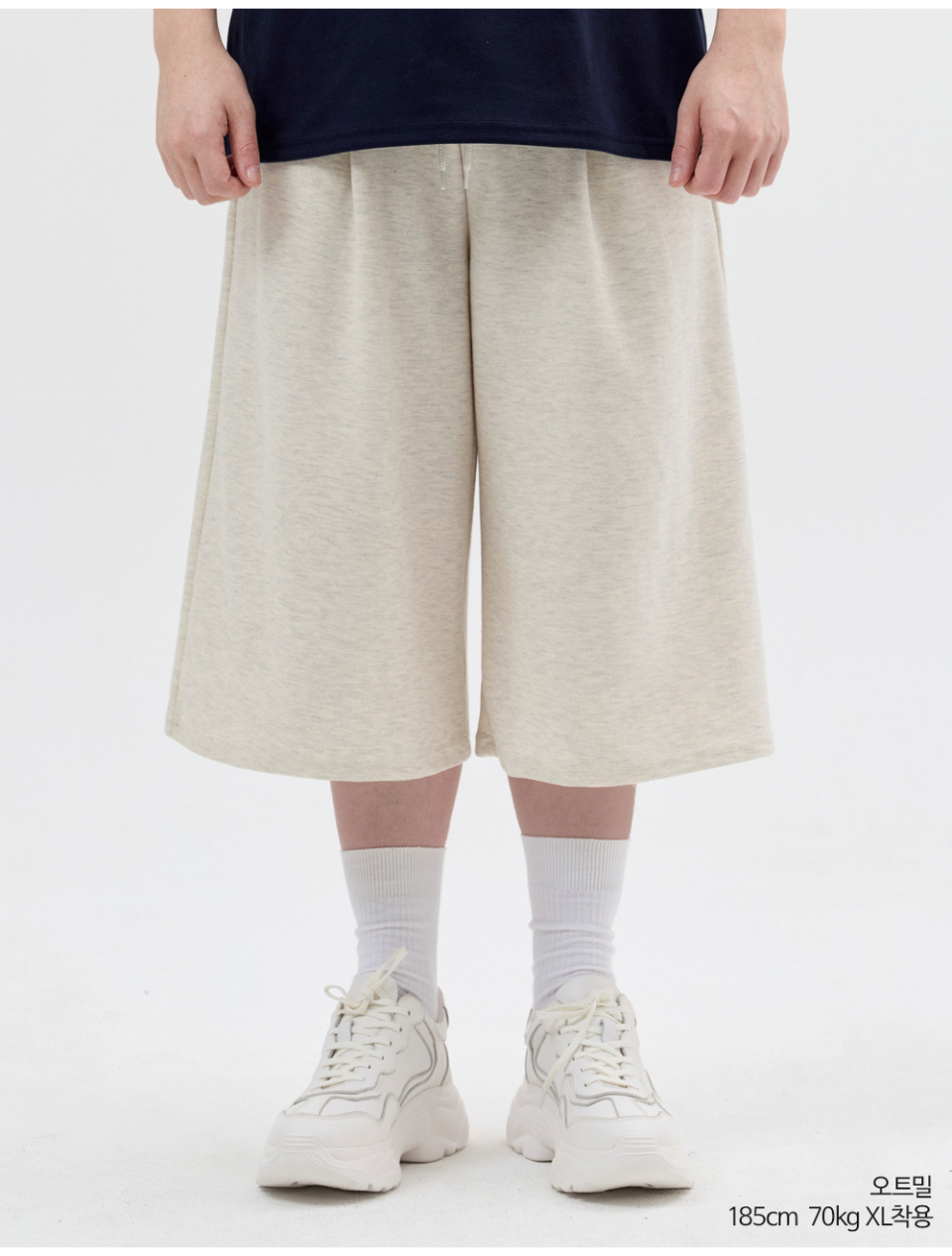 오트밀색상 8부 원턱 버뮤다 쇼츠를 입은 남자 사진