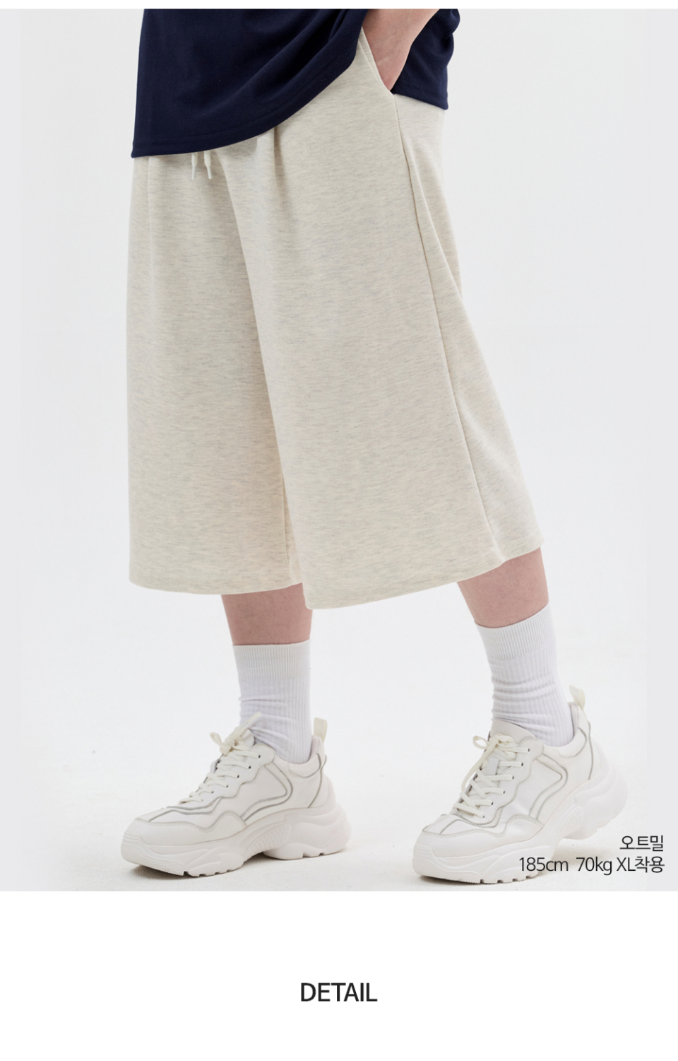 오트밀색상 8부 원턱 버뮤다 쇼츠를 입은 남자 사진